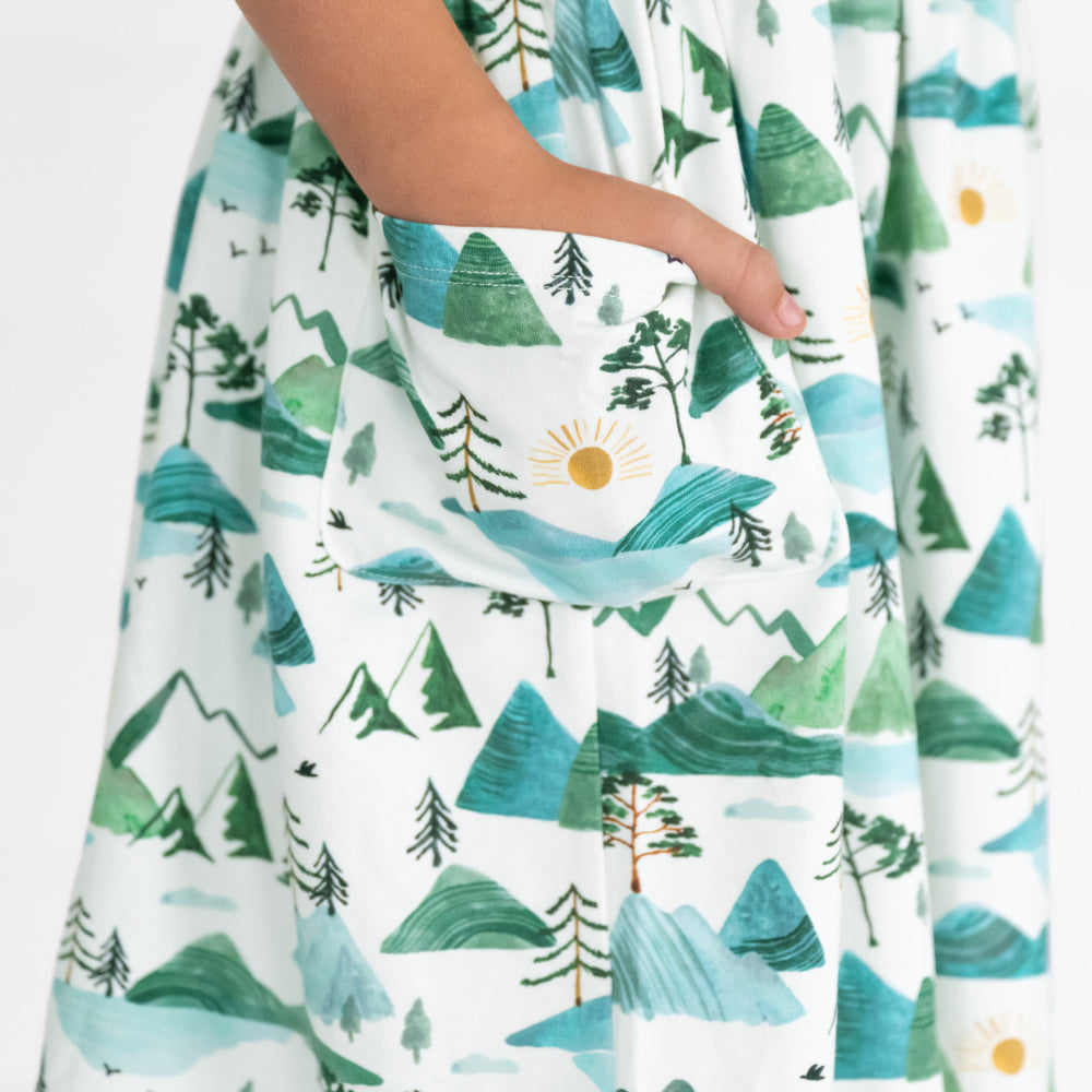 Close up image of a child wearing a Mountain Mist Patch Pocket Dress, detailing the pocket