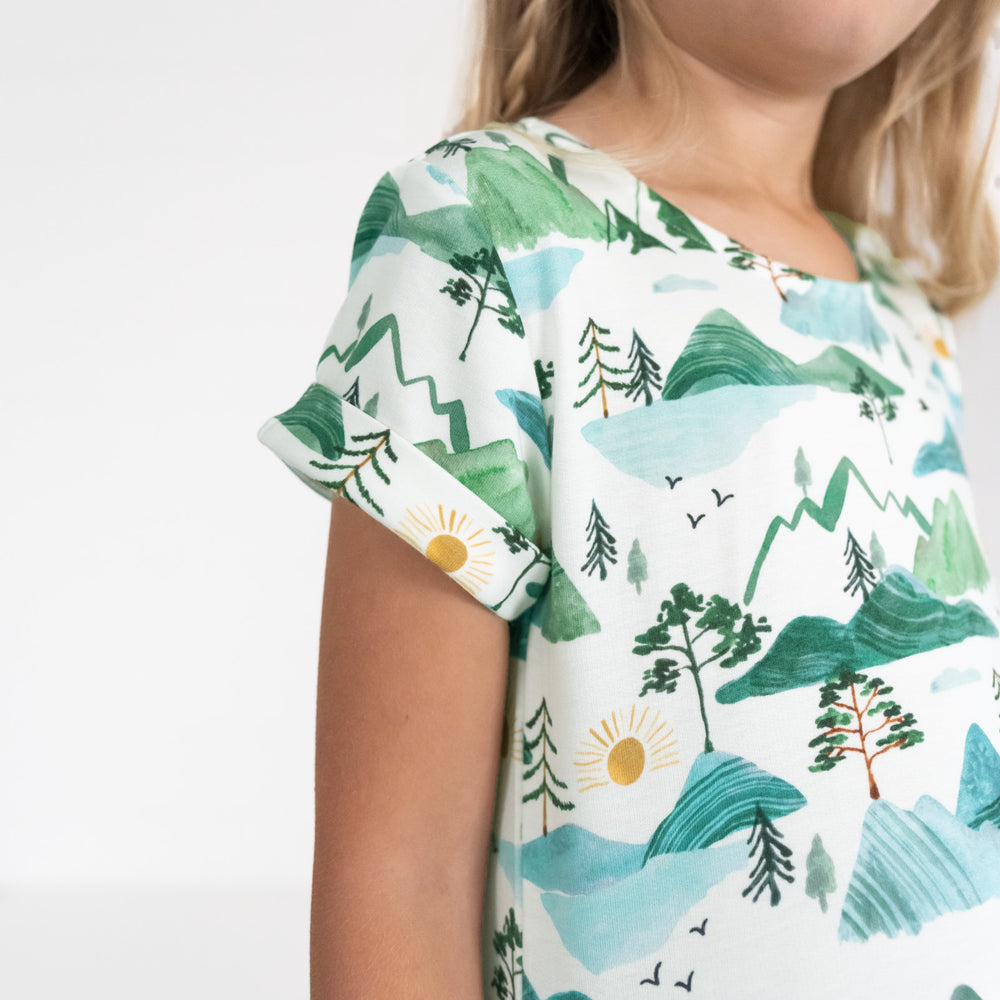 Close up image of a child wearing a Mountain Mist Patch Pocket Dress, detailing the sleeve