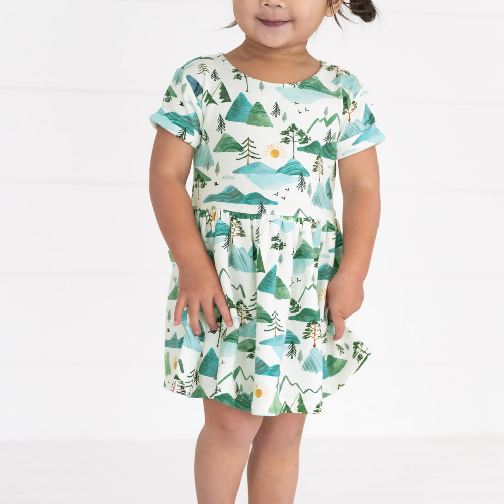 Close up image of a child wearing a Mountain Mist Patch Pocket Dress with Bloomer