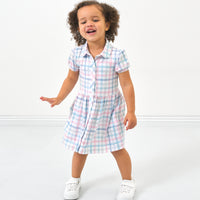Child wearing a Playful Plaid puff sleeve button down dress