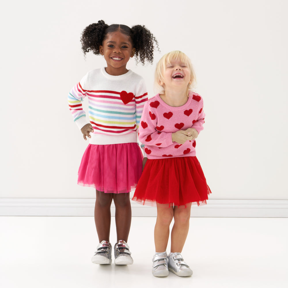 Click to see full screen - Girls laughing in striped sweater and heart sweater and tutu skirt.