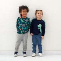 Two kids in dinosaur tee shirt and sweatshirt