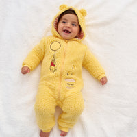Child laying on a blanket wearing a Disney Winnie the Pooh sherpa romper with the hood up