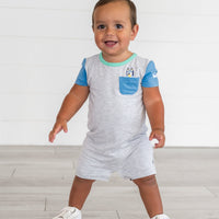 Boy standing while wearing the Bluey Graphic Pocket Shorty Romper