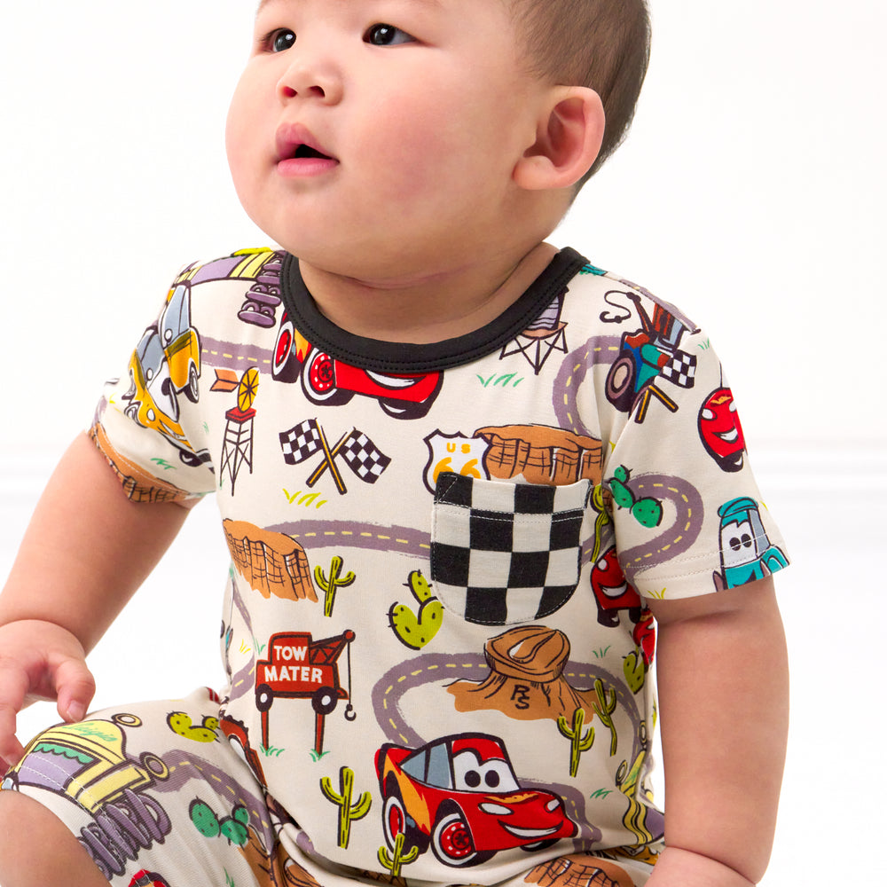 Close up image of a child wearing a Radiator Springs pocket shorty romper