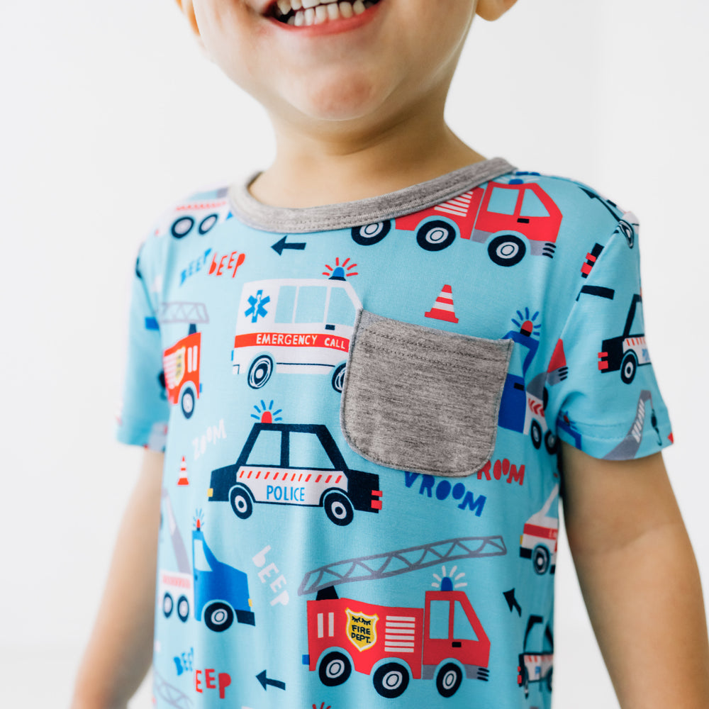 Close up image of a child wearing a To The Rescue Pocket Shorty Romper