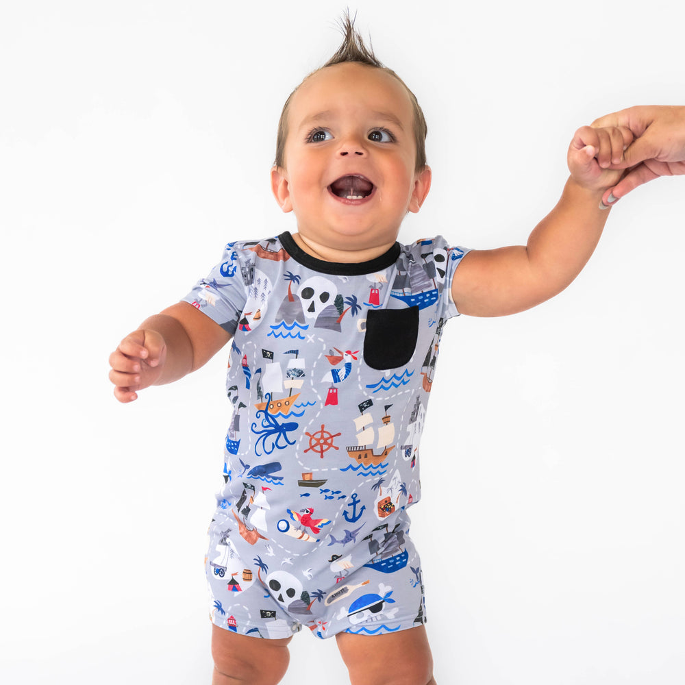 Alternative image of baby standing while wearing the Pirate's Map Pocket Shorty Romper