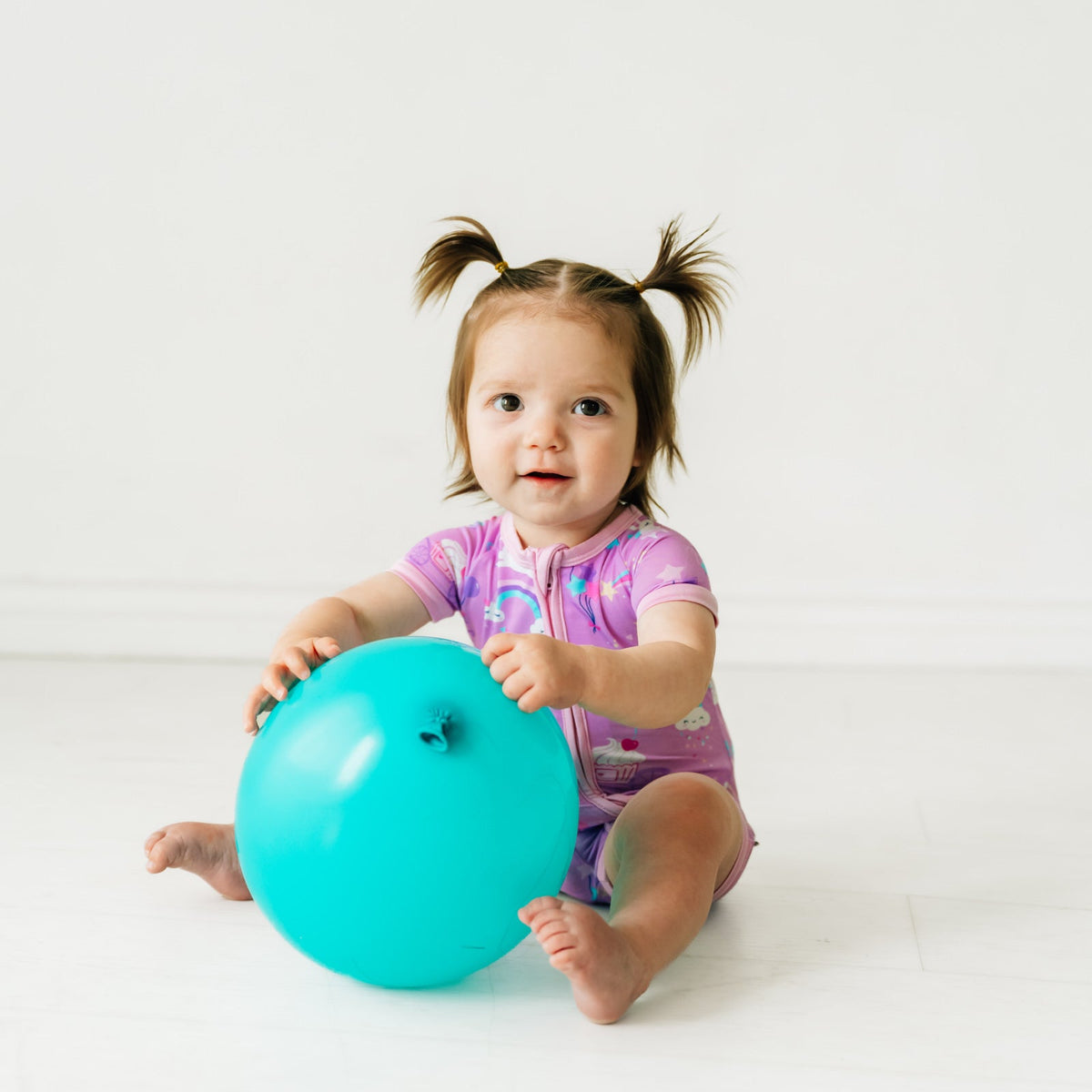 Child playing with a balloon wearing Magical Birthday shorty zippy