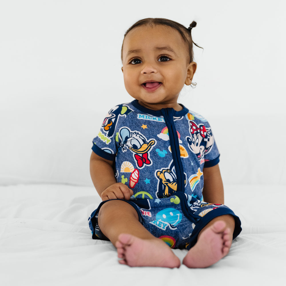 Child sitting on a bed wearing Disney Mickey's Clubhouse bamboo baby pajamas