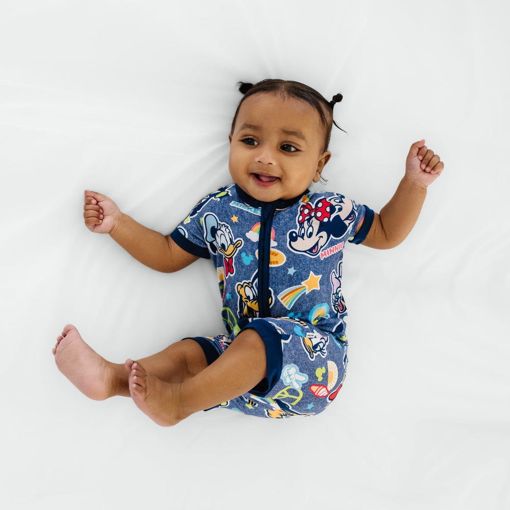 Ariel view of a child laying on a bed wearing Disney Mickey's Clubhouse bamboo baby pajamas