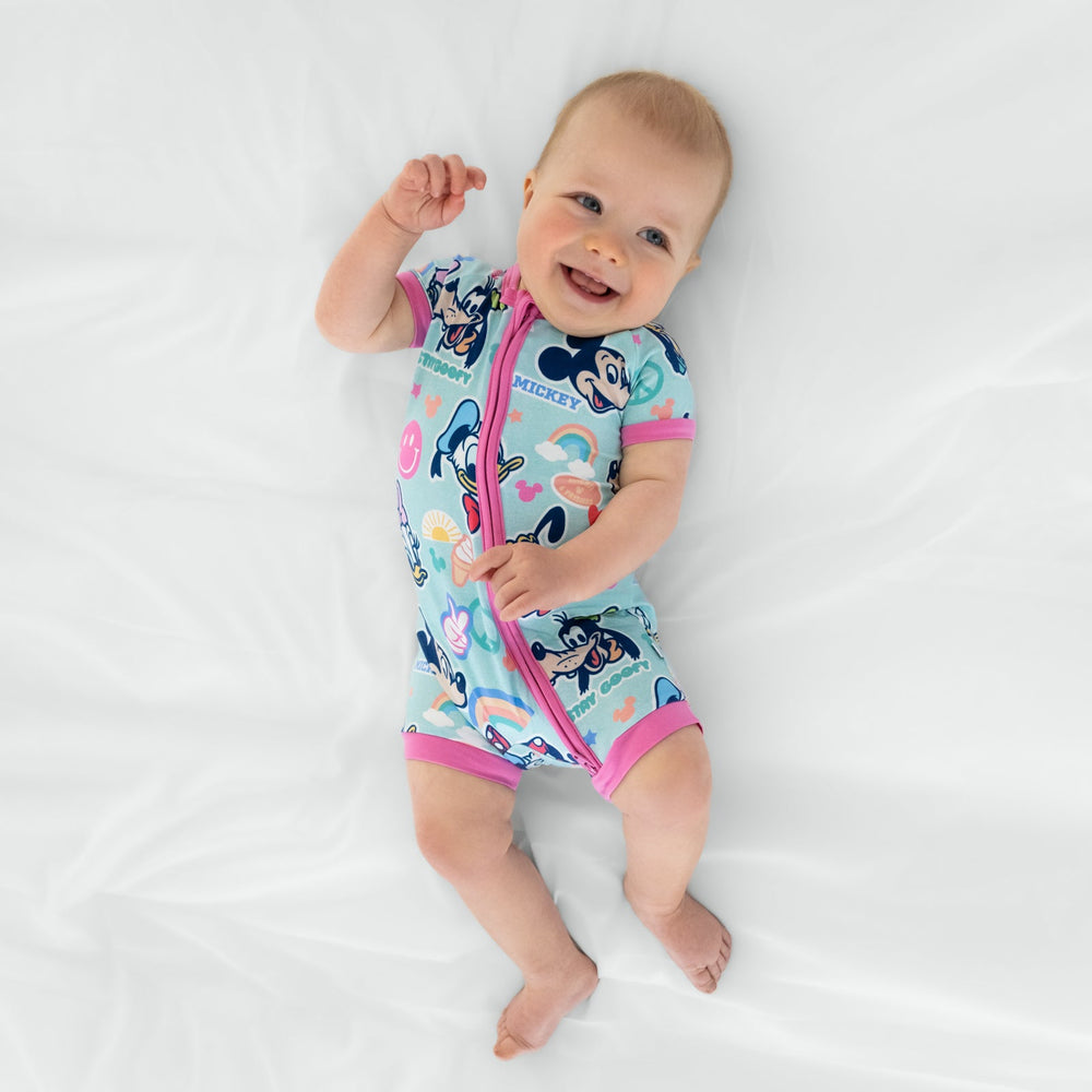 Ariel view of a child laying on a bed wearing Pink Disney Mickey's Clubhouse bamboo baby pajamas