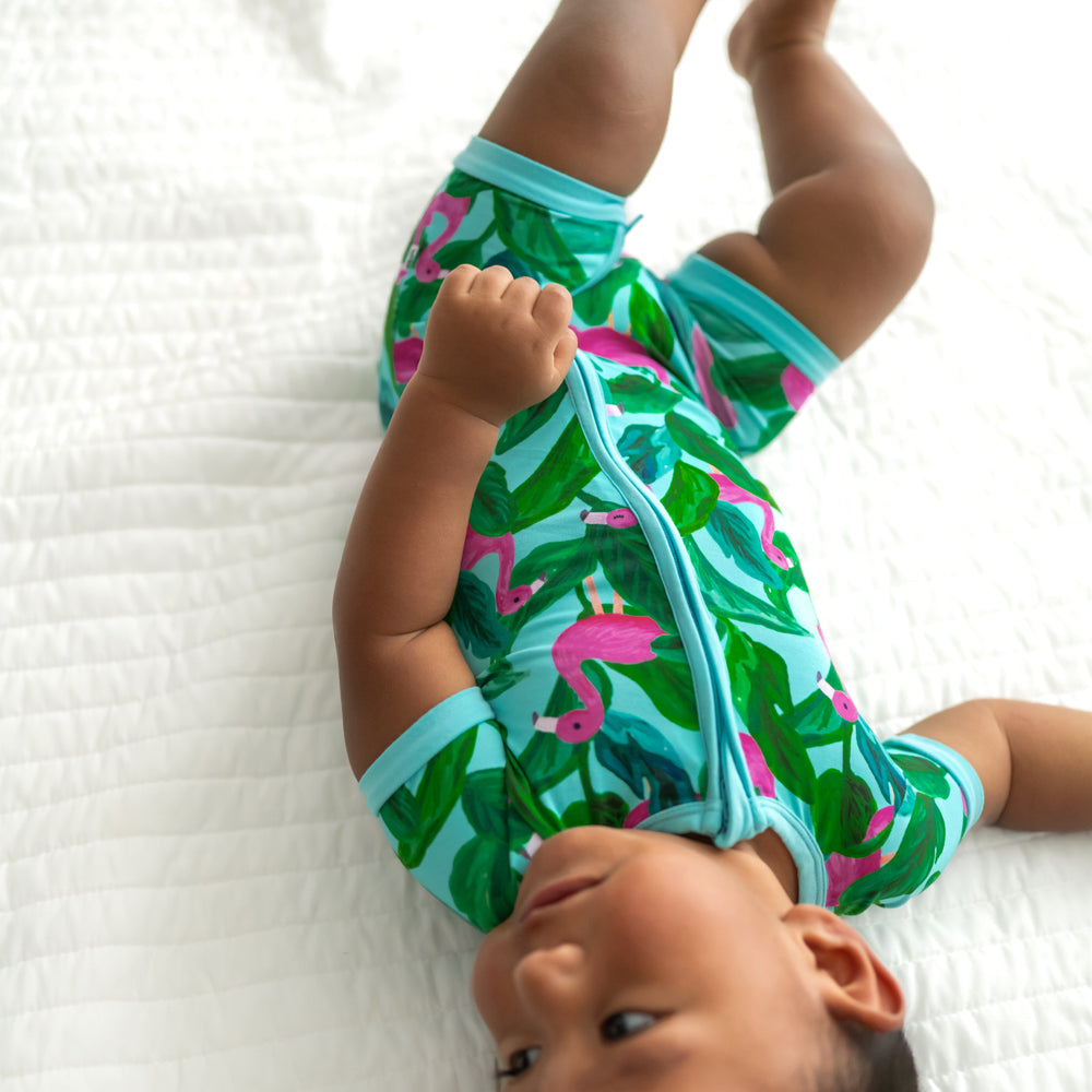 Child laying on a bed wearing a Palm Springs shorty zippy