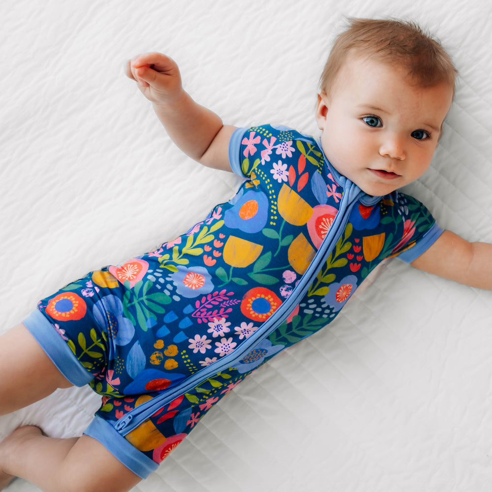 Baby laying down while wearing the Folk Floral Shorty Zippy