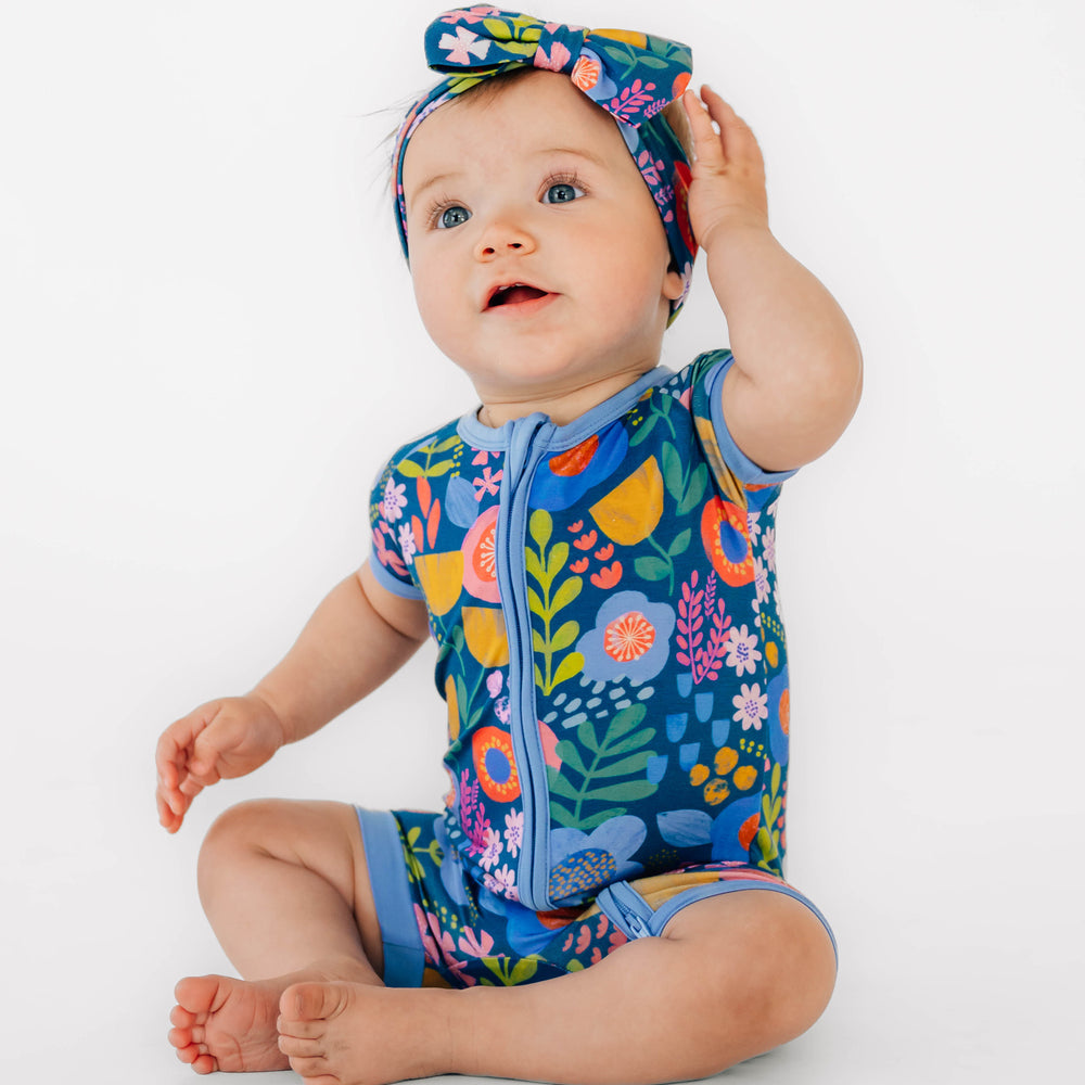 Baby sitting while wearing the Folk Floral Shorty Zippy and Folk Floral Luxe Bow Headband