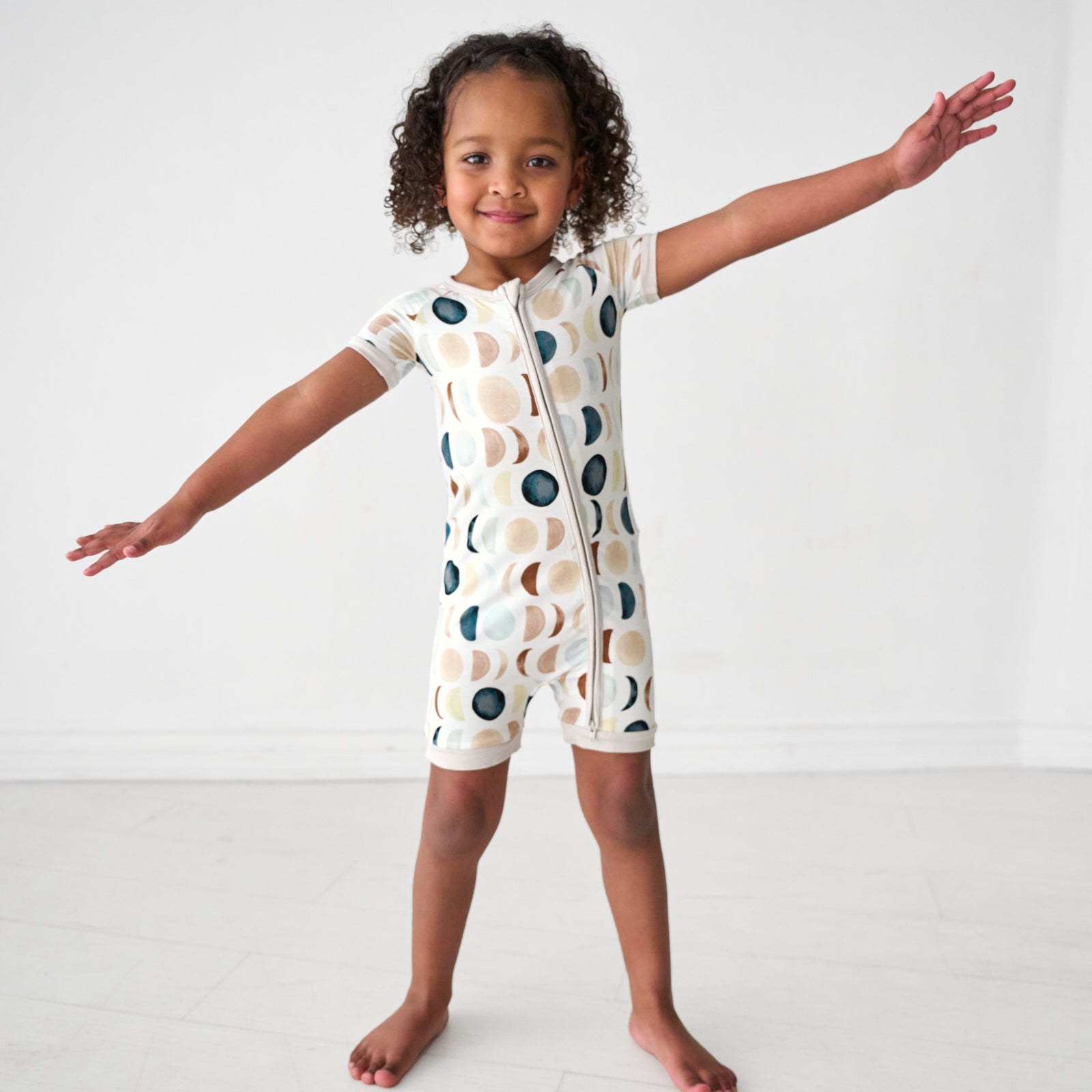 Child wearing a Luna Neutral shorty zippy