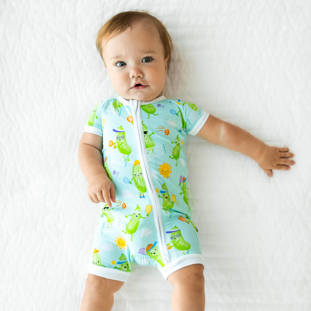 Baby laying down wearing the Pickle Power Shorty Zippy