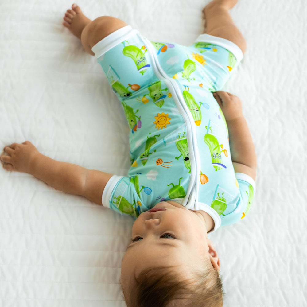 Alternative view of baby laying down wearing the Pickle Power Shorty Zippy