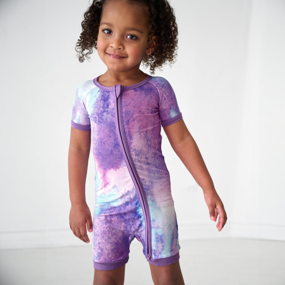 Close up image of a child wearing a Purple Watercolor shorty zippy