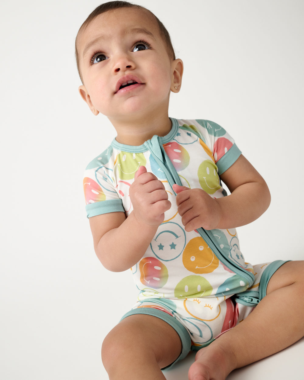Close up of sitting child wearing the Positive Vibes Shorty Zippy