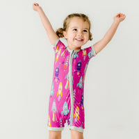 Child posing wearing a Pink Space Explorer shorty zippy