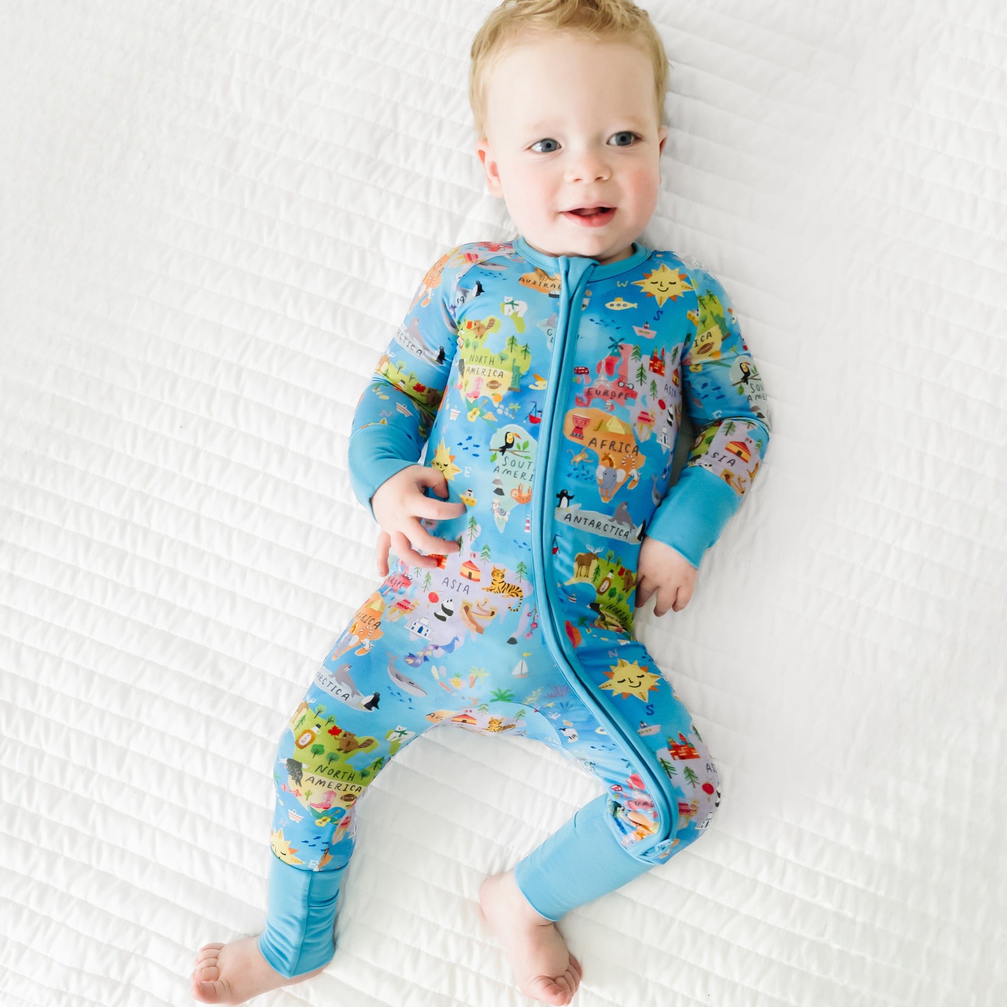 Child laying on a bed wearing an Around the World Zippy