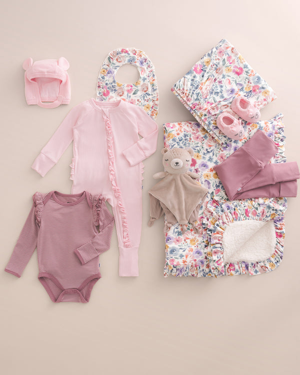 Styled flats of Prima Pink, Rosewood, and Tiny Blooms newborn clothing