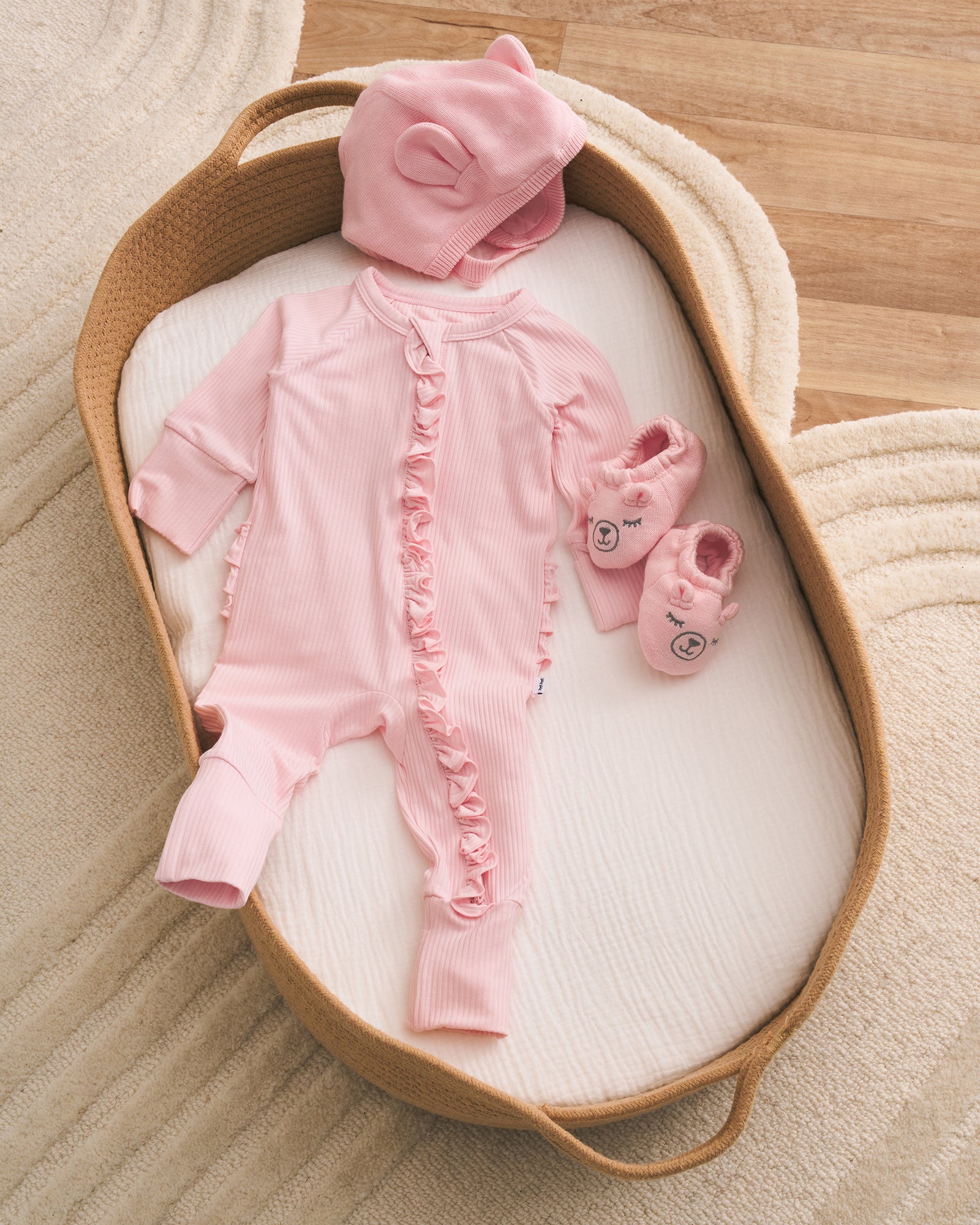 Newborn girl outfit laid out on a crib