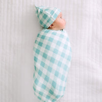 Child swaddled in a Aqua Gingham swaddle and hat set