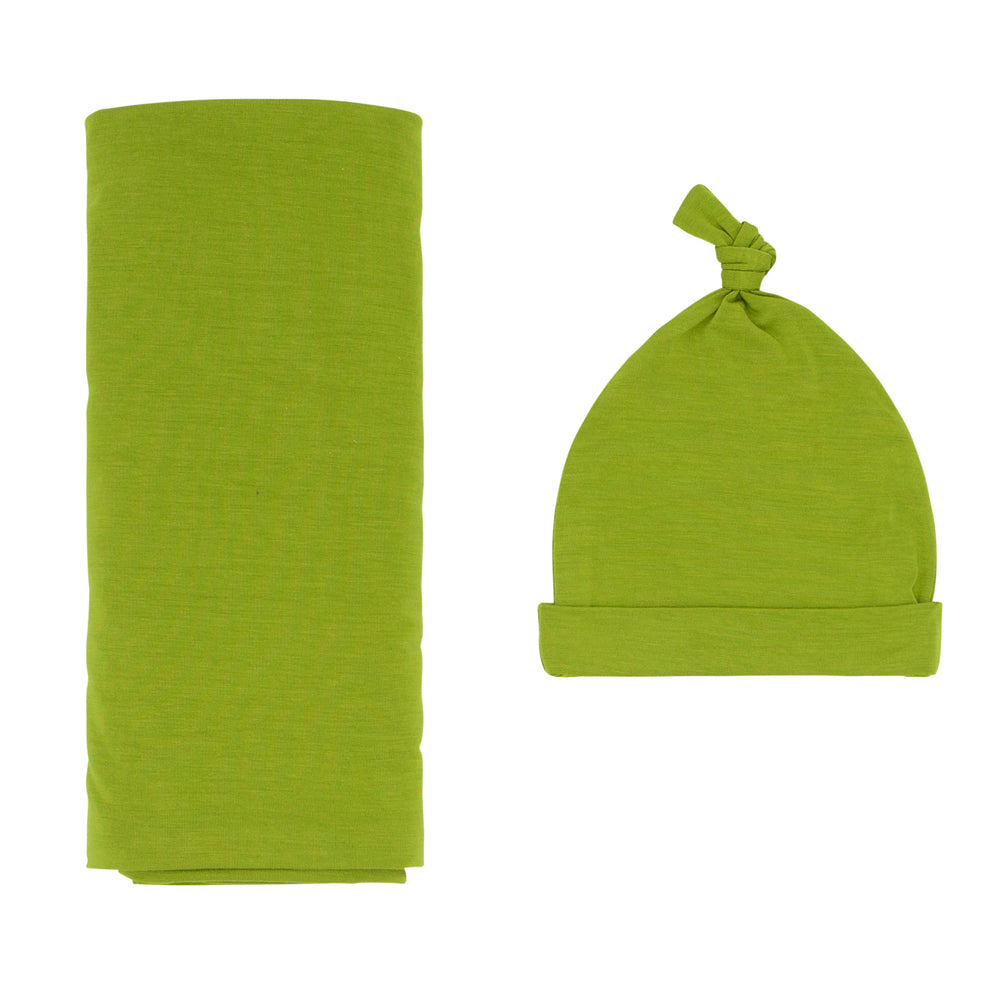 Flat lay image of an Avocado swaddle and hat set