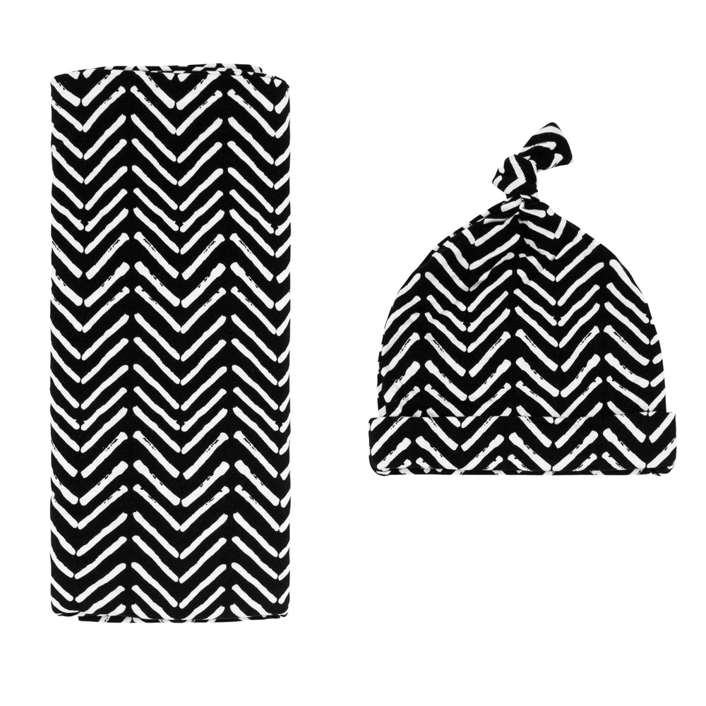 Flat lay image of a Monochrome Chevron swaddle and hat set