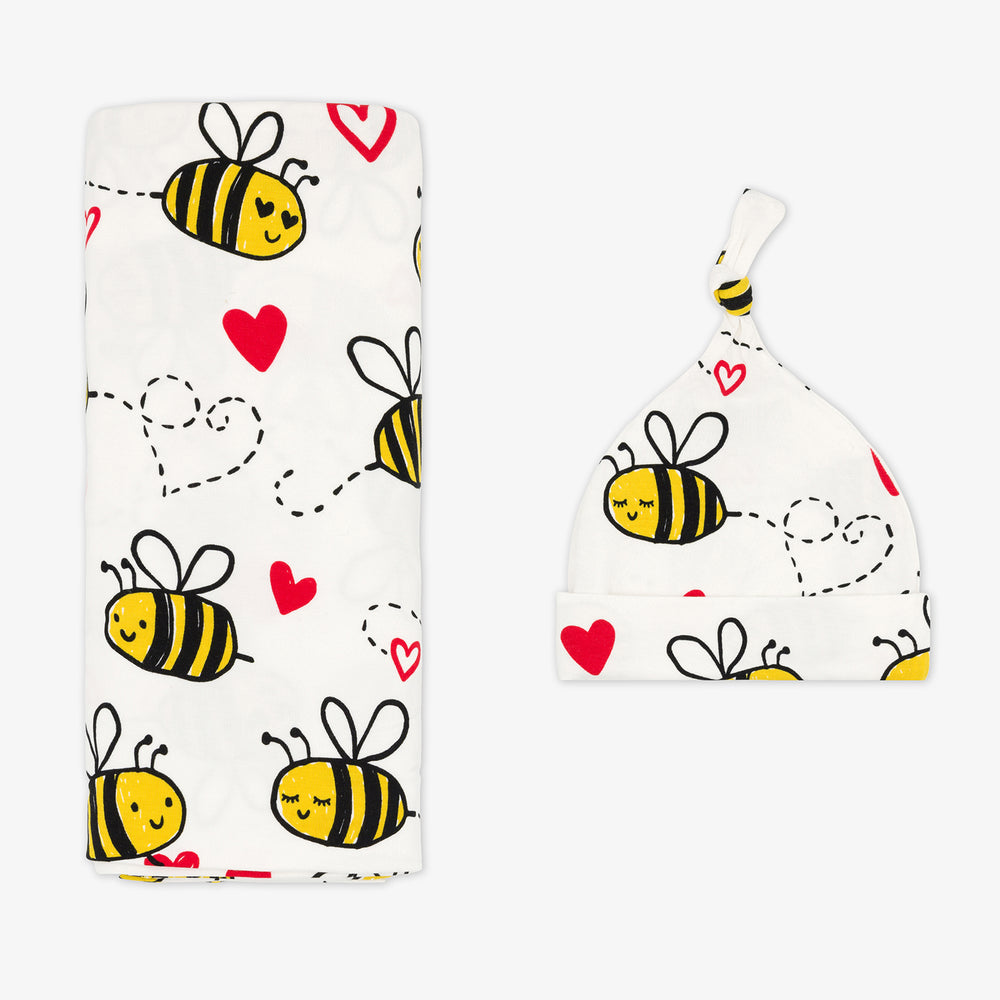 Flat lay image of a Bee Mine swaddle and hat set 