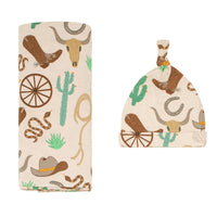 Flat lay image of a Caramel Ready to Rodeo swaddle and hat set
