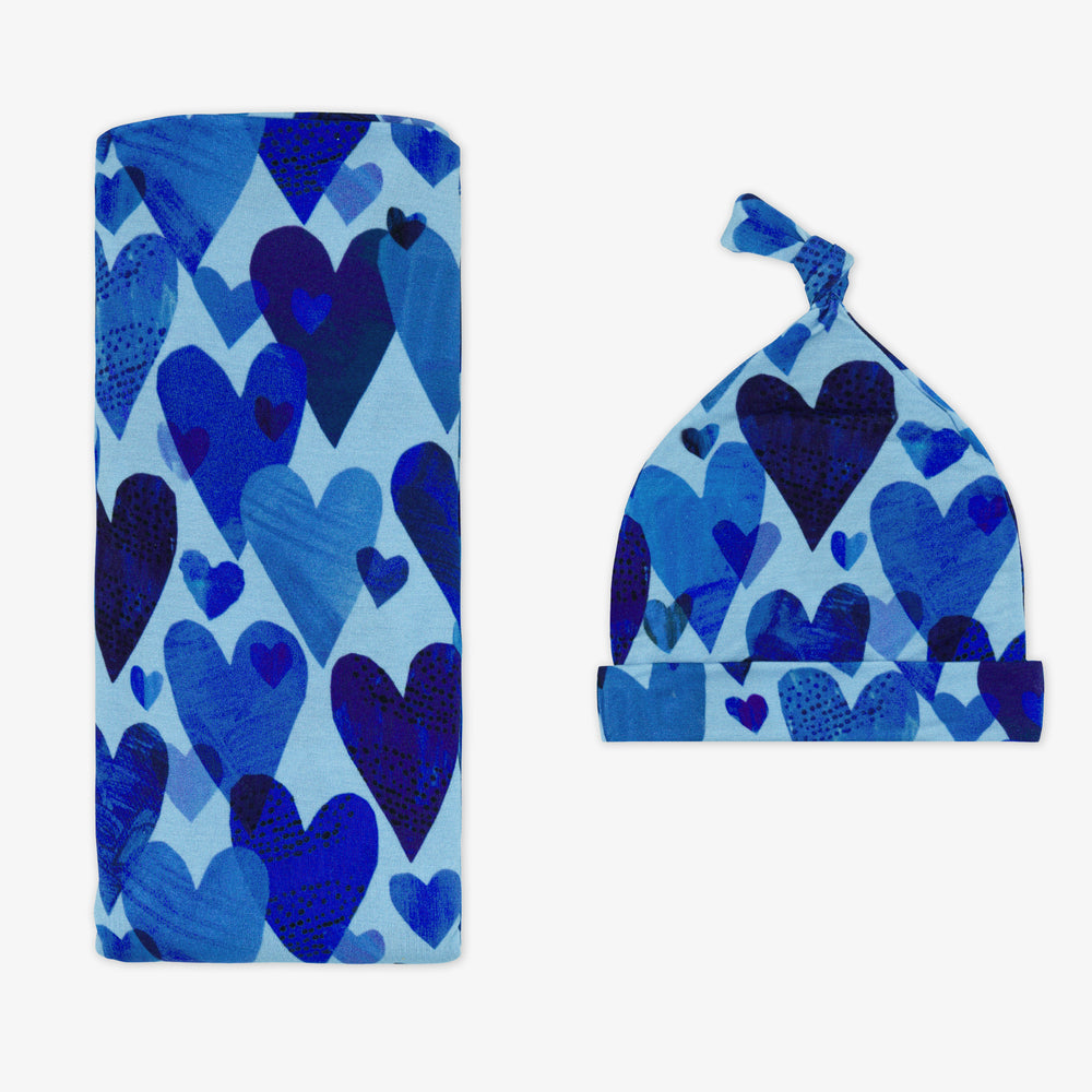 Flat lay of Blue Hearts & Crafts swaddle and hat set.