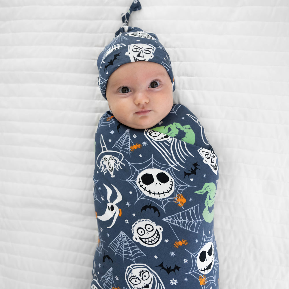 Close up top view image of baby laying down in the Disney Jack & Crew Swaddle & Hat Set