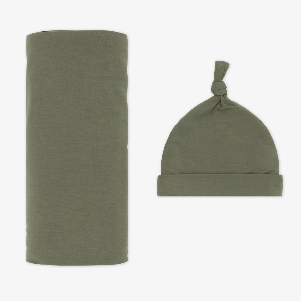 Flat lay image of a Cozy Olive swaddle and hat set