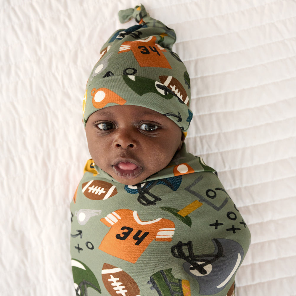 Close up image of baby in the Touchdown Time Swaddle & Hat Set