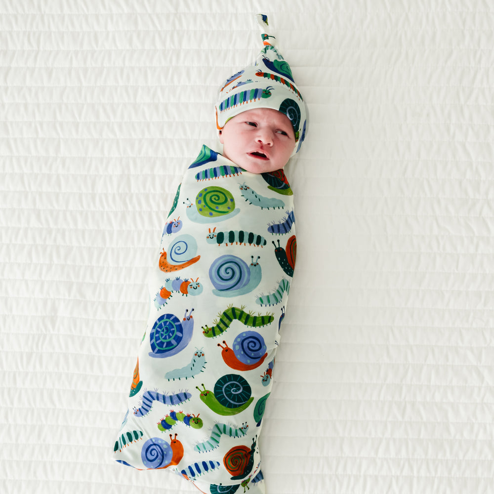 Infant swaddled in an Inchin' Along swaddle & hat set