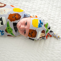 Close up image of an infant swaddled in a Legends of the Galaxy swaddle & hat set
