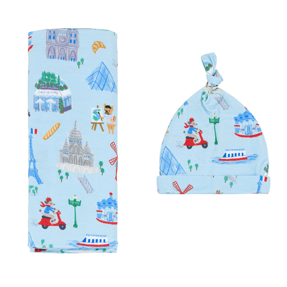 Flat lay image of the Blue Weekend in Paris Swaddle & Hat Set