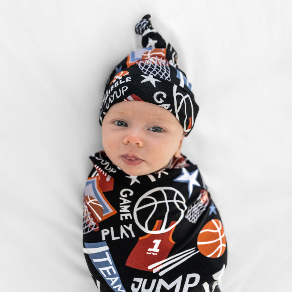 Close up of baby in the Black Slam Dunk bamboo swaddle and hat set