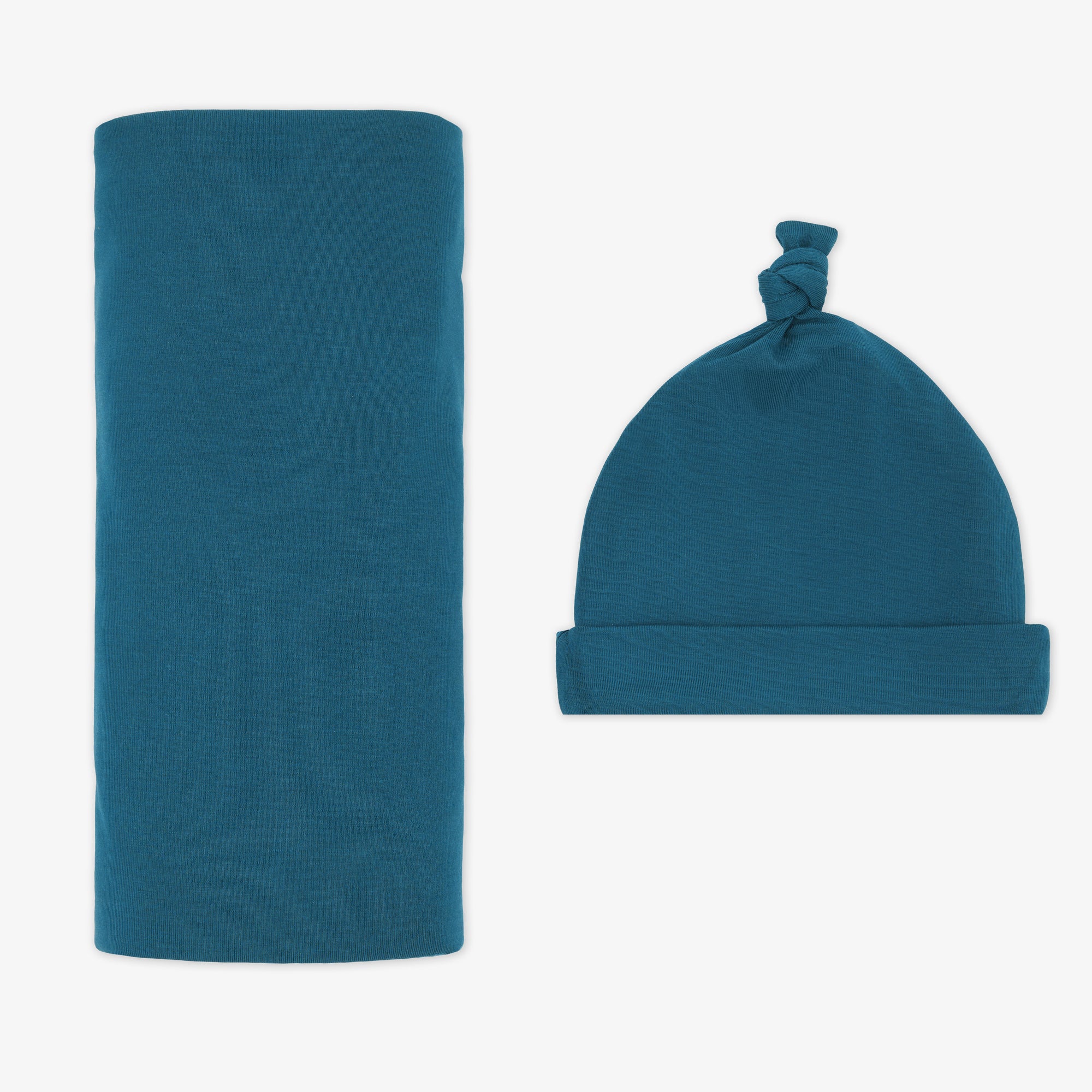 Flat lay image of a Cozy Twilight Teal swaddle and hat set