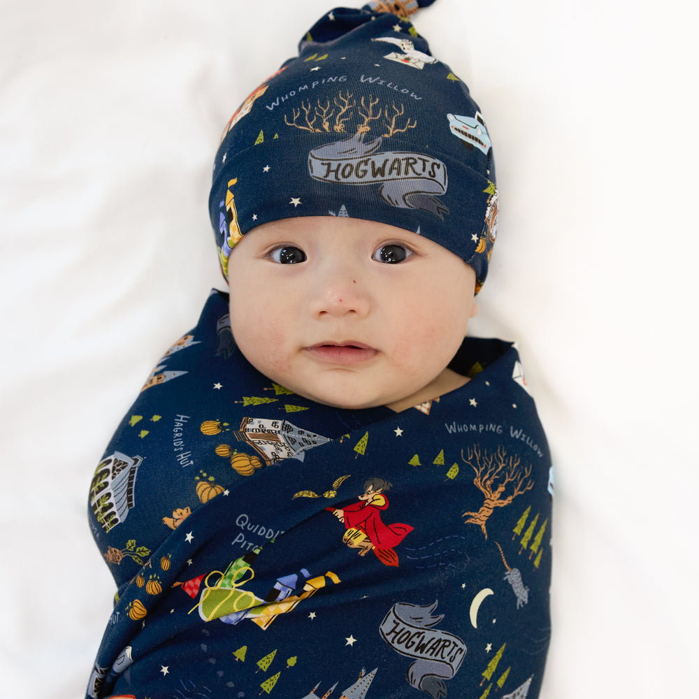 Close up image of a child swaddled in an Evening at Hogwarts swaddle and hat set