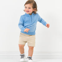 Child wearing Light Khaki chino shorts and a coordinating zip sweater
