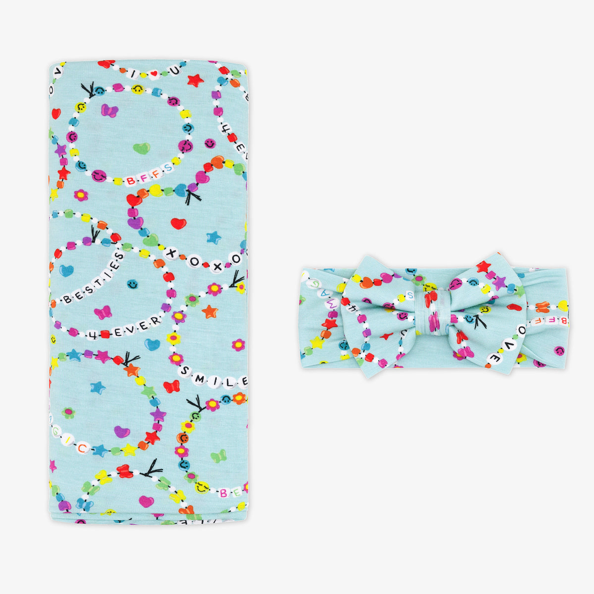 Flay lay image of a Friends Forever swaddle and bow set