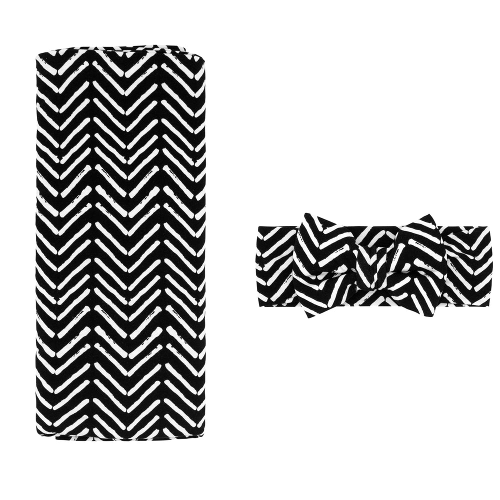 Flat lay image of a Monochrome Chevron swaddle and luxe bow headband set