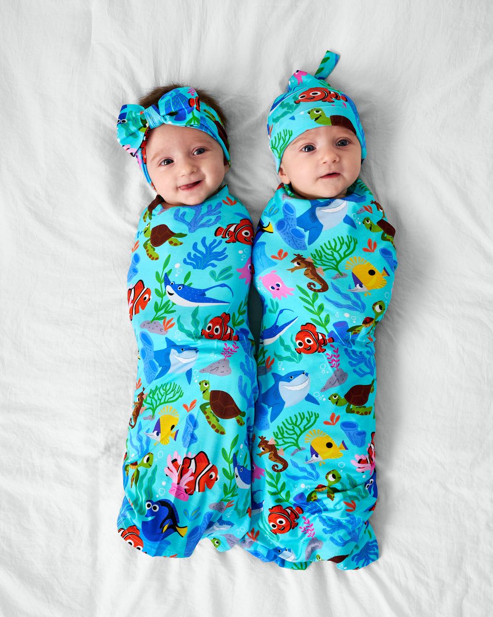 Two children wearing Disney Nemo's Reef Bamboo Swaddle Sets