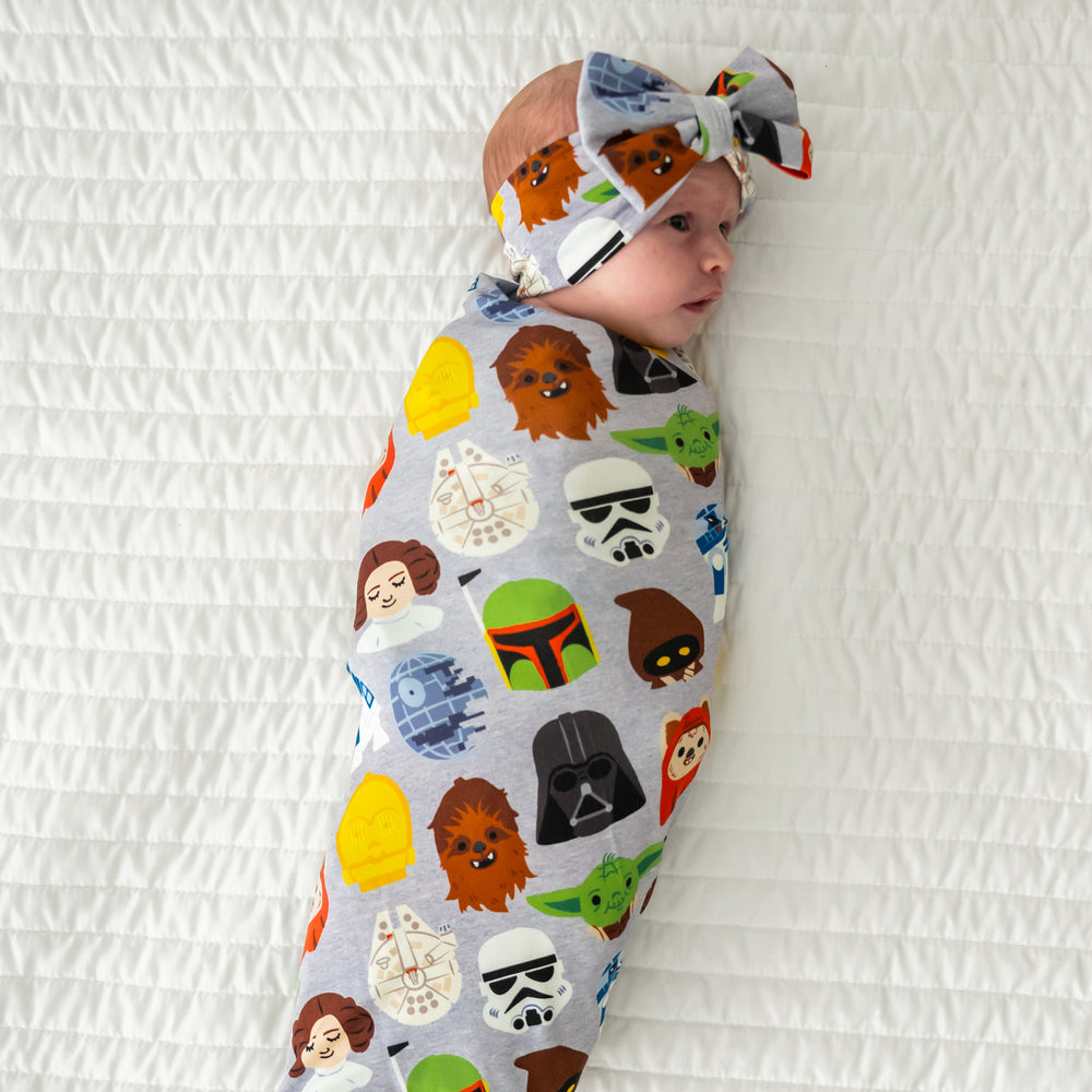 Infant swaddled in a Legends of the Galaxy swaddle & luxe bow headband set