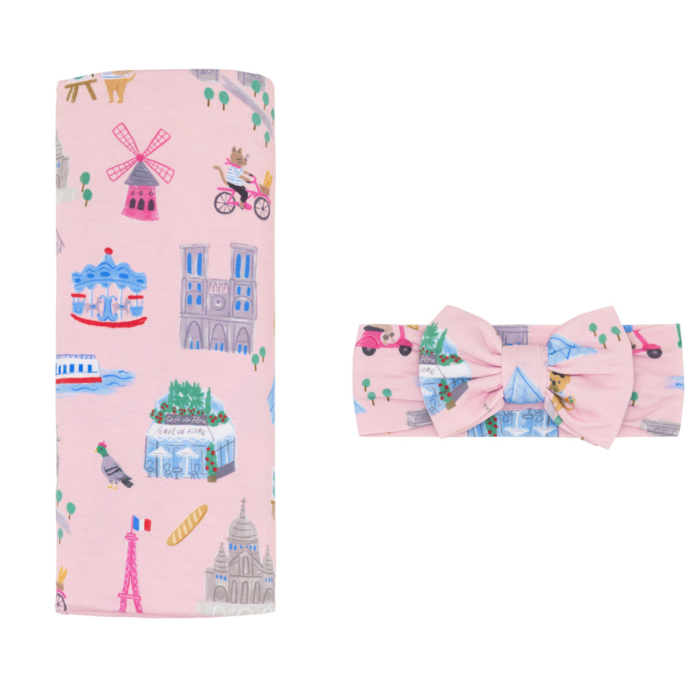 Flat lay image of the Pink Weekend in Paris Swaddle & Luxe Bow Headband Set