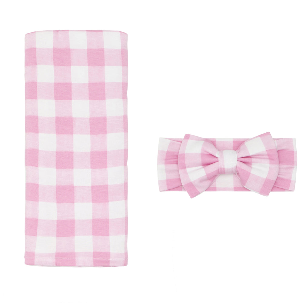 Click to see full screen - Flat lay image of a Pink Gingham swaddle and luxe bow headband set