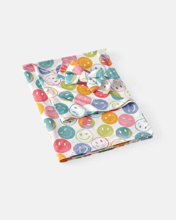 Flat lay of the Positive Vibes Swaddle & Luxe Bow Headband Set